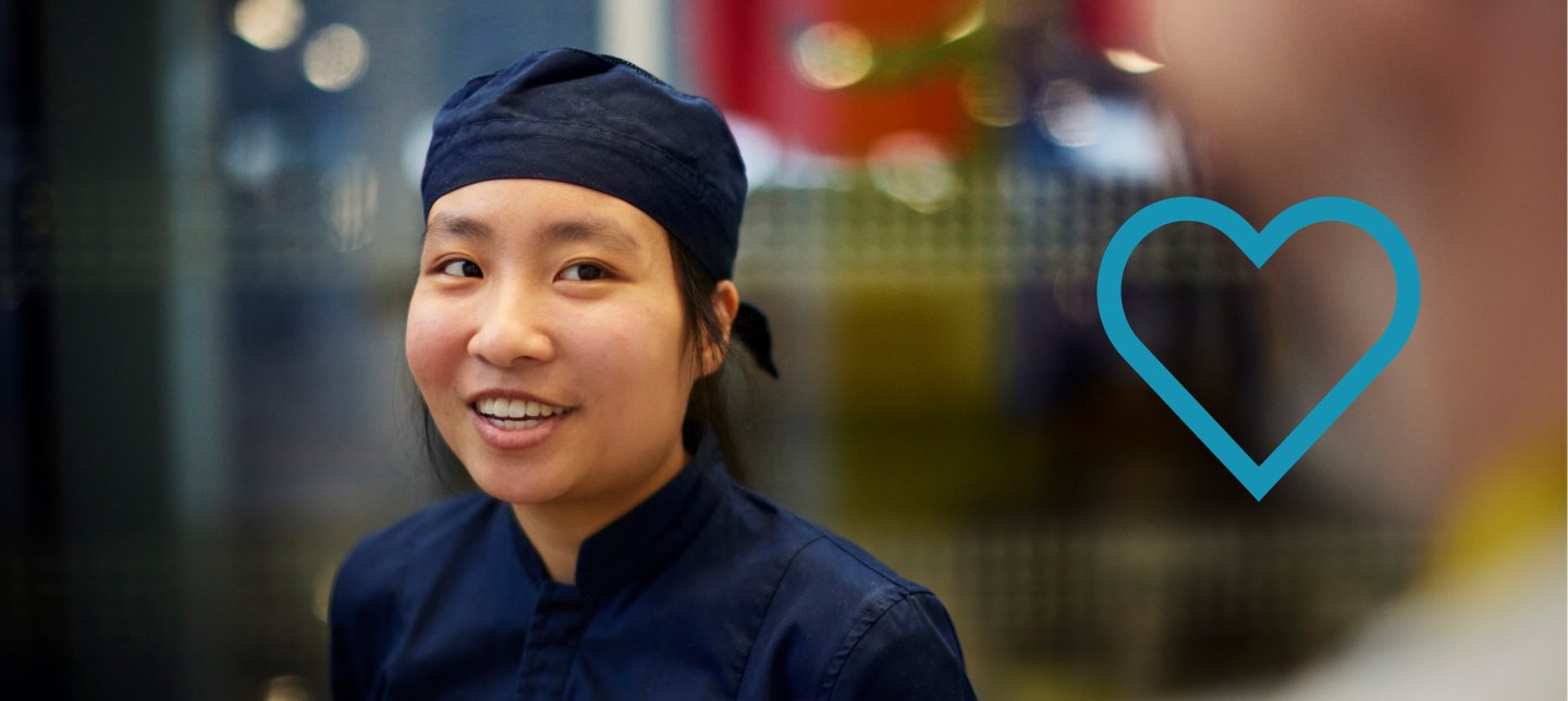 An IKEA Food co-worker wearing a blue work uniform in front of a blurred background.