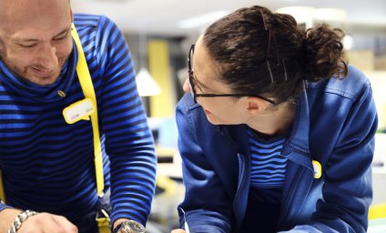 Two IKEA retail employees laughing together in the textile section.