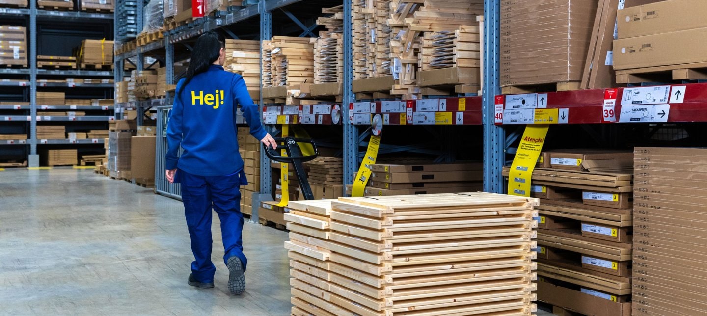 An IKEA employee with a hand truck restocking in the stores Self-service area