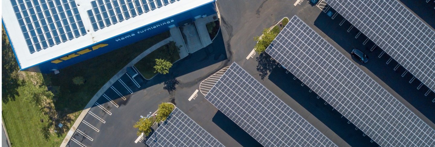 Drone image of an IKEA store and several solar panels on the ground next to it.