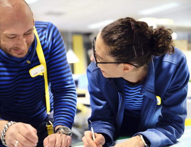 Two IKEA retail employees laughing together in the textile section.