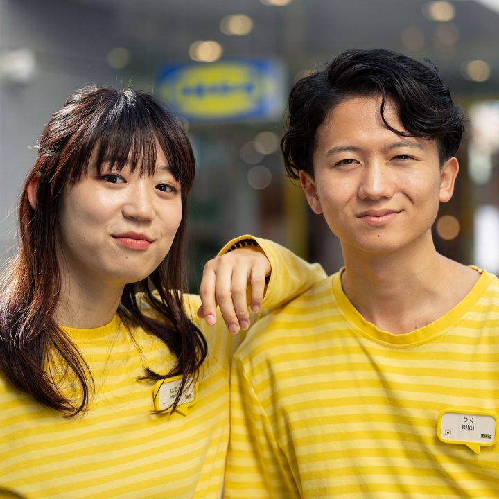 Two IKEA colleagues wearing yellow shirts standing in a store.