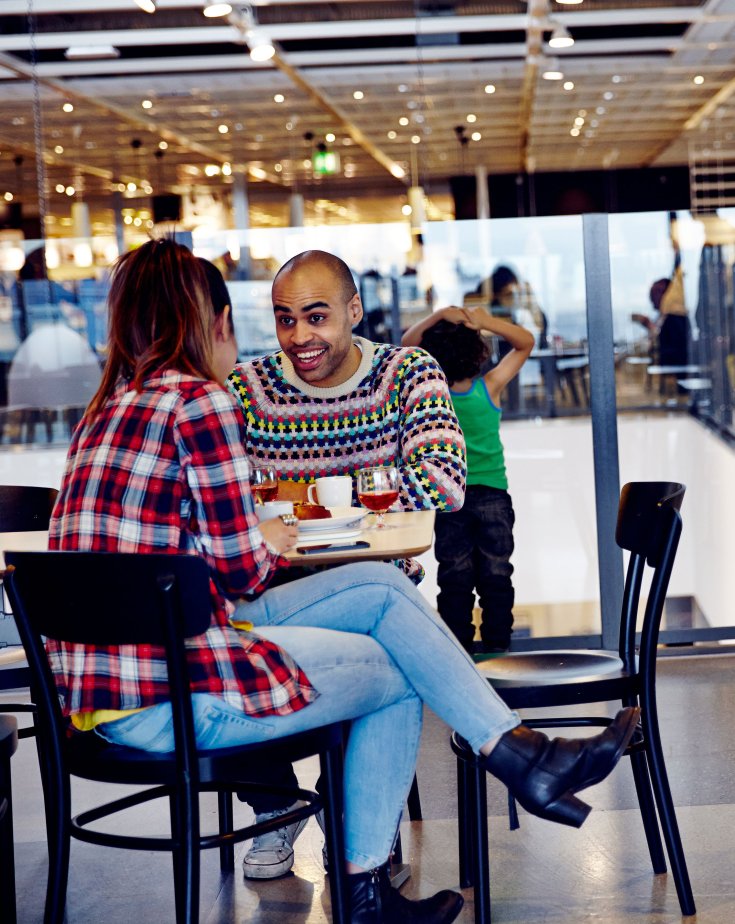 Two people chatting and laughing while eating at the IKEA restaurant.