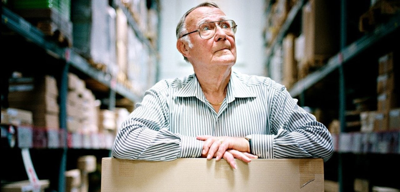 Ingvar Kamprad standing in the IKEA store ware-house with a cardboard box.